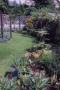 A curving lawn leads further into the garden